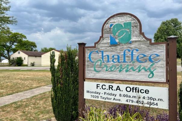 A wooden sign post that reads "Chaffee Crossing" and includes F.C.R.A office hours and location.