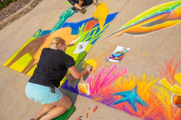 woman drawing with chalk on sidewalk