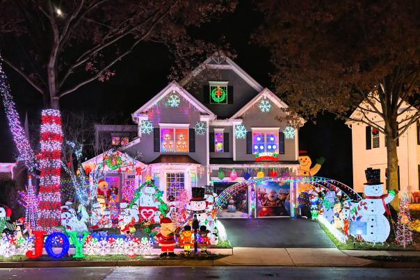 a residential home completely covered in christmas lights of all covers and christmas-themed figurines