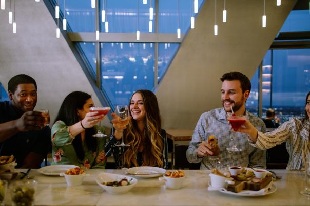 A group of friends raising their glasses to cheers at Vast