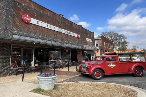 front of the UG White storefront in downtown Athens with an old timey truck parked out front