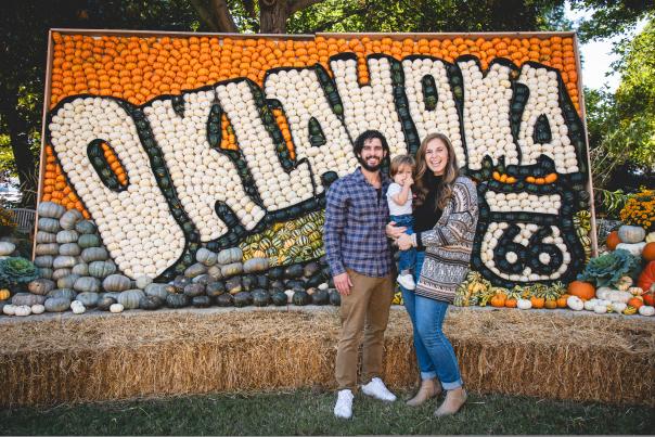 Family standing in front of pumpkin display