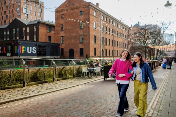 Two visitors walking down canal street