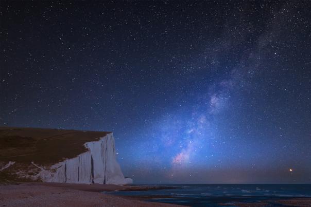 stargazing - milkyway visible at night in a dark skie over seven sisters cliffs