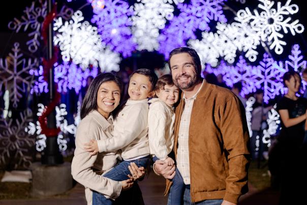 Family posing in front of lights at Glendale Glitters