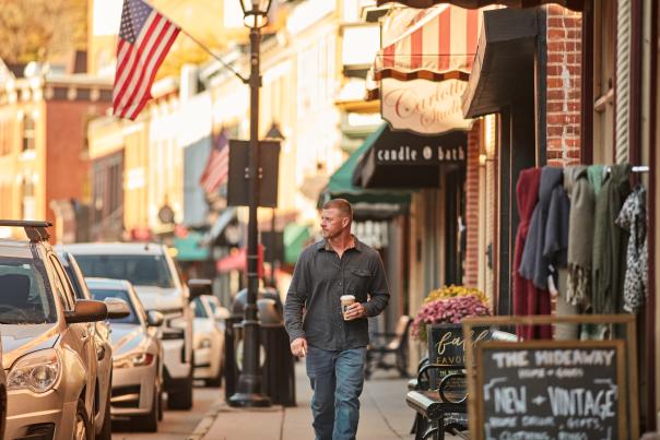 Man walking down Main Street in Galena, holding a cup of coffee.