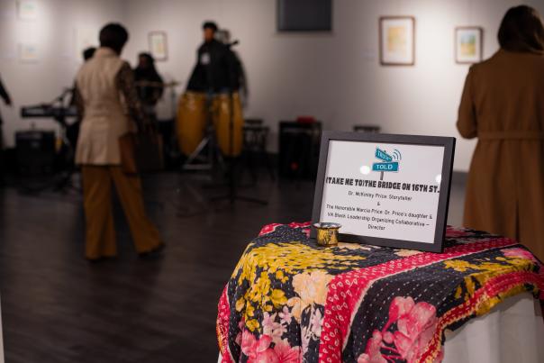 A table set in a gallery reads "take me to the the bridge on 16th street"