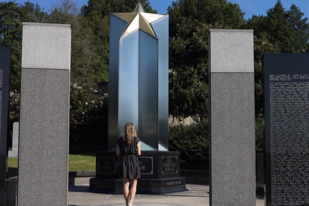 a woman stands in front of the Wold War II Memorial in Annapolis, MD