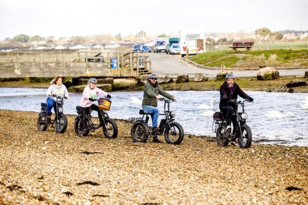 Four people riding with Jaunte Bike cycling on the beach