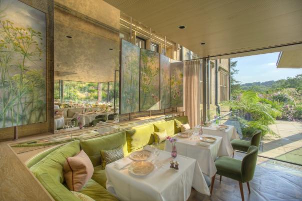 Interior tables at Gravetye Manor restaurant, with patio doors leading out to gardens