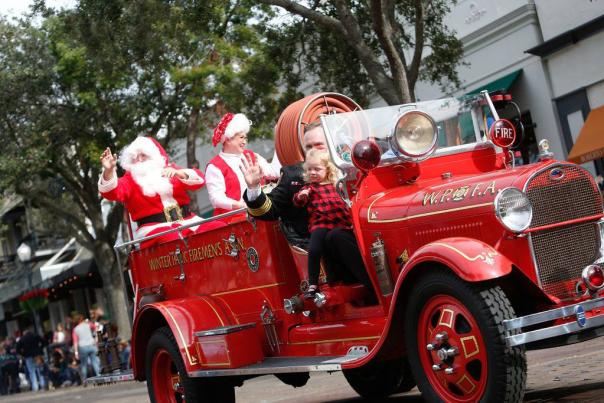 Santa rides a fire truck in the Winter Park Christmas Parade