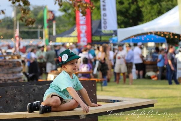 A young boy sitting on a bench at Cullman's Oktoberfest.