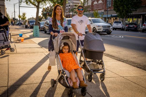 Family with kids in strollers walking downtown