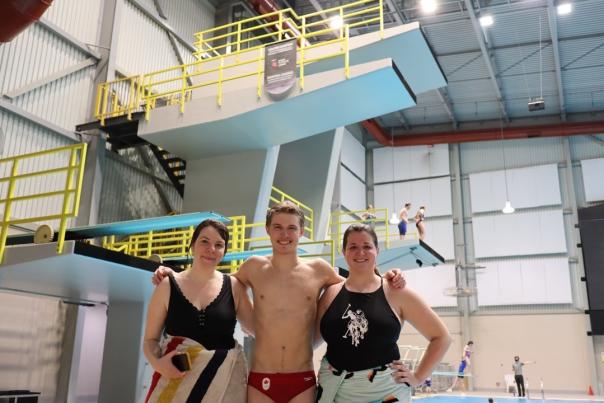 darby, rylan, heather, arm in arm, standing in front of diving platforms