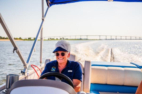 Captain Paula steering the boat with 2-10 Bridge in the background