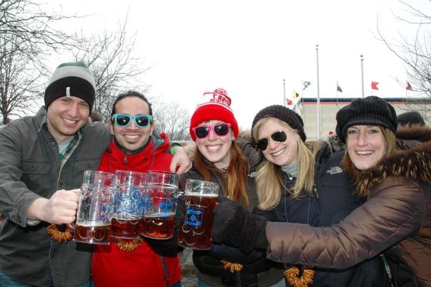 A group of five friends clinking beer steins outside at Bockfest
