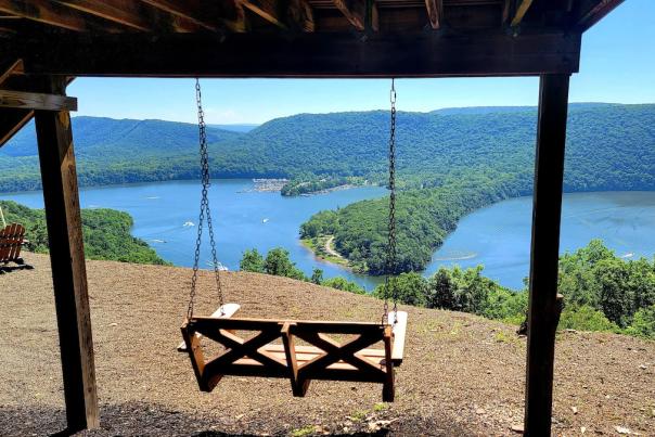 A swing overlooking a lake on a sunny day
