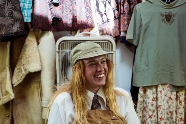 A person standing in front of the clothing they sell.