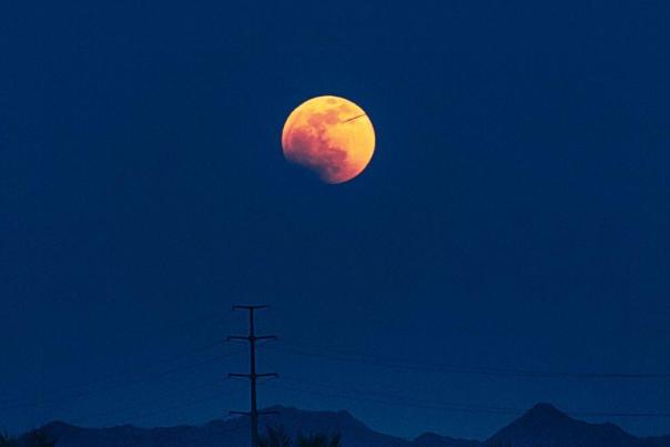 a night photo by @mirceagoia showing the moon and its craters