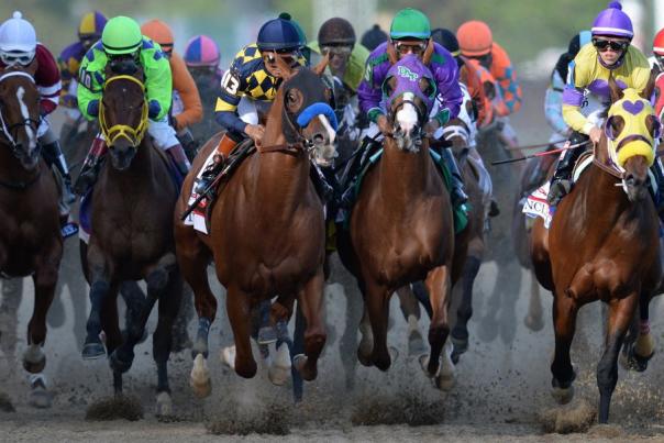 Horses and jockeys racing toward the camera at the Kentucky Derby