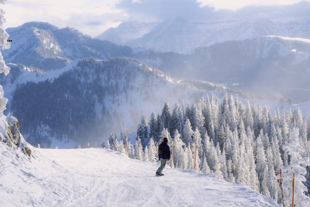 Snowboarder going down the Great Western at Brighton Resort, UT.