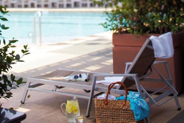 Chaise lounge and beach bag poolside