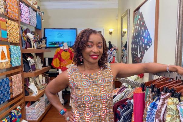 Nita Brown, owner of Mansawear inside her shop with colorful fabric and clothing in background