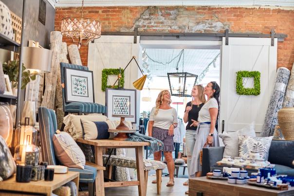 Three people in a home goods store, looking at merchandise.