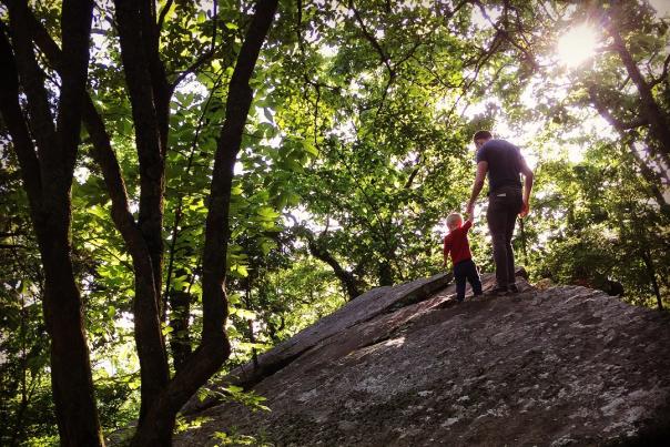 Father and Son Hiking on large rock