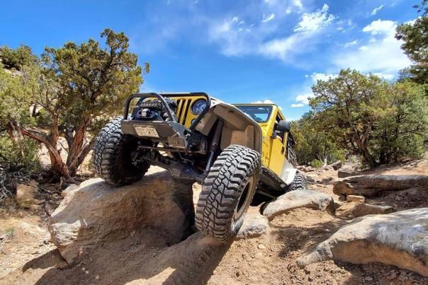 Picture of Yellow Jeep Driving Over Big Rock