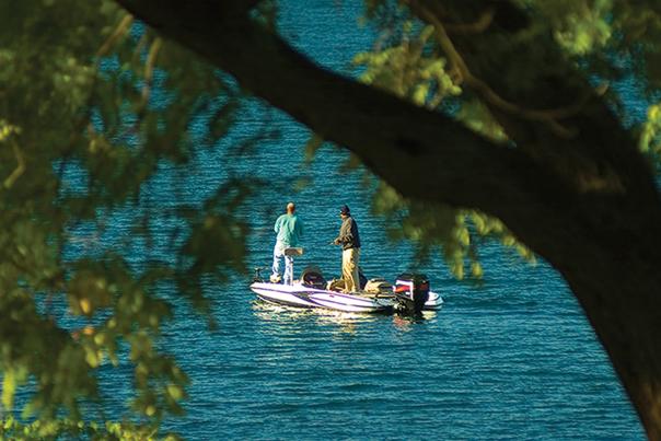 Two people fishing off a boat on Owasco Lake in Auburn New York.