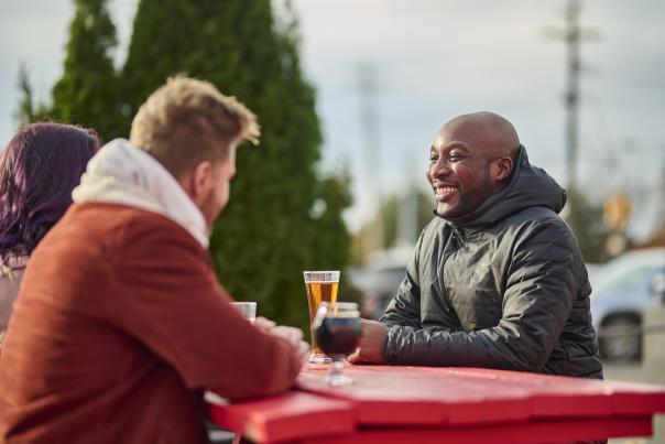 A group of friends bundled up and enjoying drinks on the patio at Lansing Brewing Company