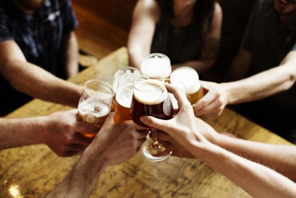 A group of people around a table cheersing their glasses