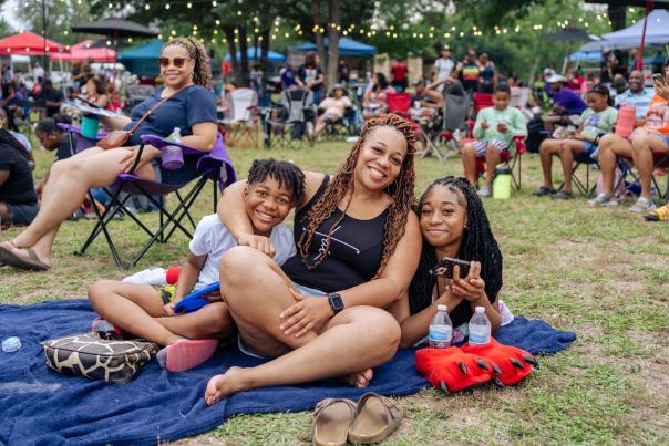 Mom and kids sitting on a picnic blanket at Juneteenth