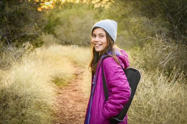 A young girl smiles back at the camera while out on a hike in San Marcos, Texas