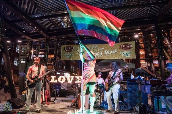 musician on stage waiving pride flag