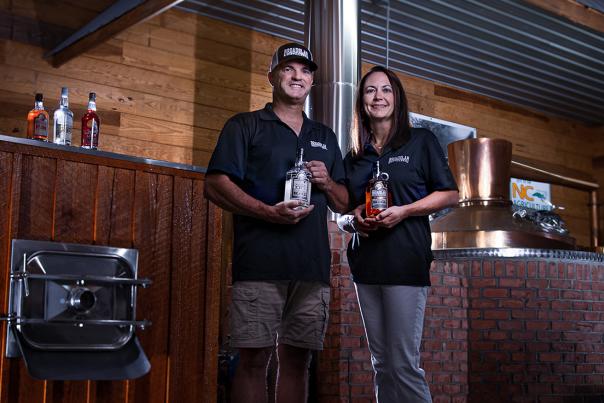 Jeremy & Shelly Norris of Broadslab Distillery Pose in front of Still