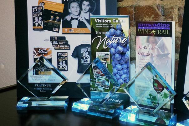 A display of Johnston County Visitors Bureau marketing samples with awards won in front of them.
