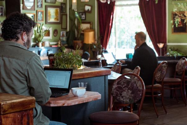 Inside of a cafe with people working on their laptops and ordering food.