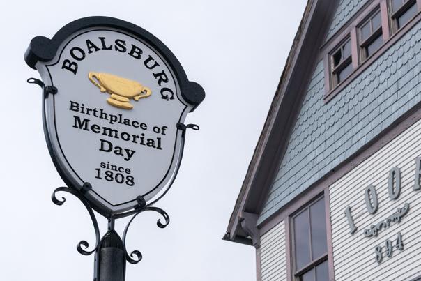 An old school historic marker on a Main Street that reads Boalsburg Birthplace of Memorial Day