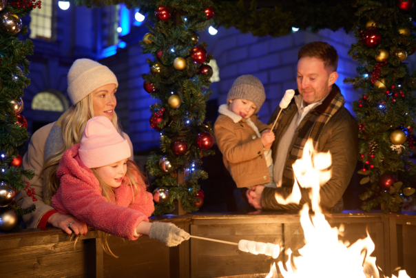 Family roasting marshmallows at Belfast Christmas Markets.