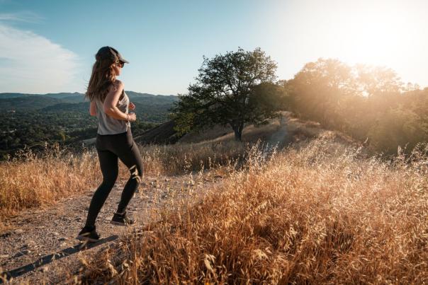 Girl running on trail in Atascadero during golden hour with a view of the sky