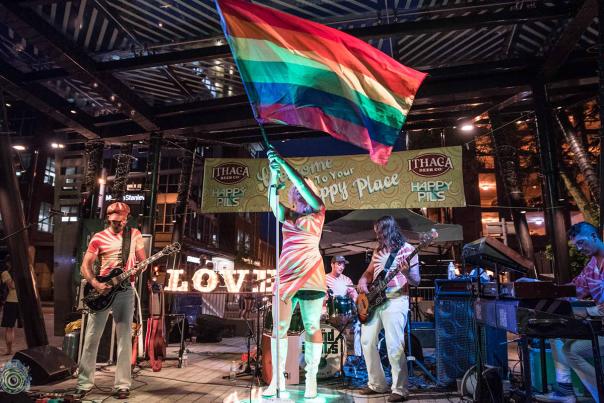 musician on stage waiving pride flag