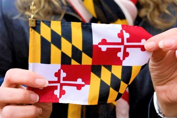 a woman holds a small Maryland Flag