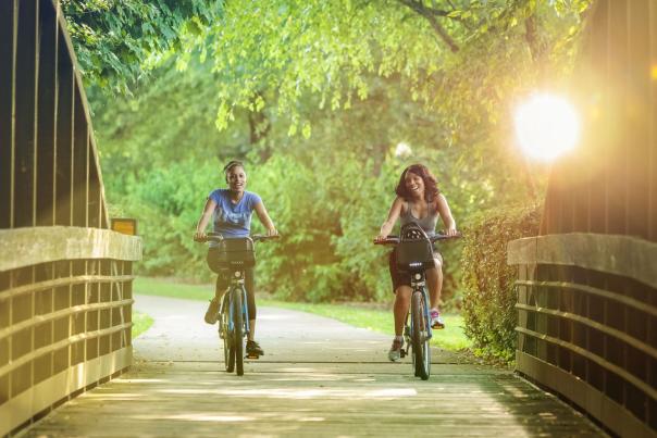 two women use bike chattanooga bikes to bike across riverwalk bridge