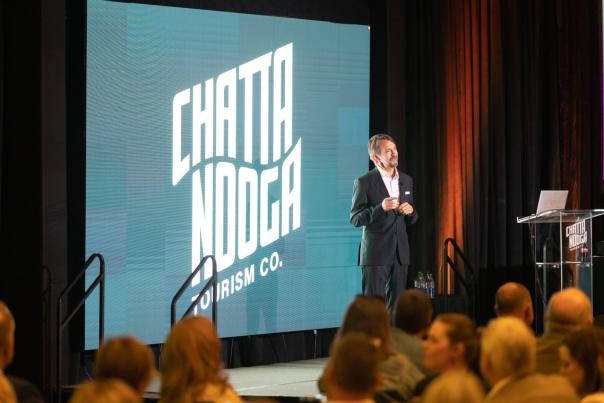 Barry speaks at 2022 Chattanooga Tourism Summit with logo behind him