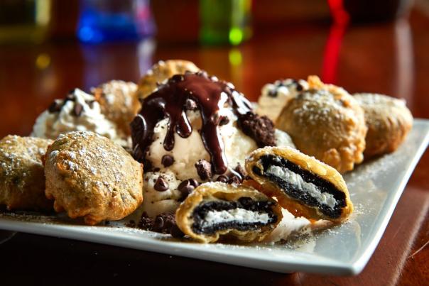 Deep-fried Oreo bites topped with ice cream and drizzled with chocolate syrup