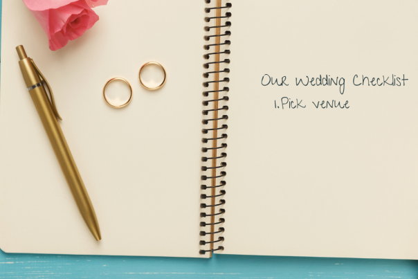 Open A5 notepad with gold pen & 2 wedding rings: Wedding Checklist