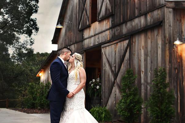 Bride and groom in front of barn