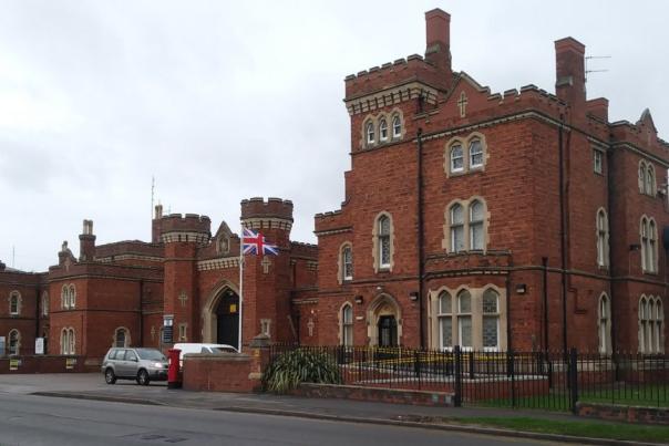 A view of Lincoln Prison, a historic red brick building with elaborate windows